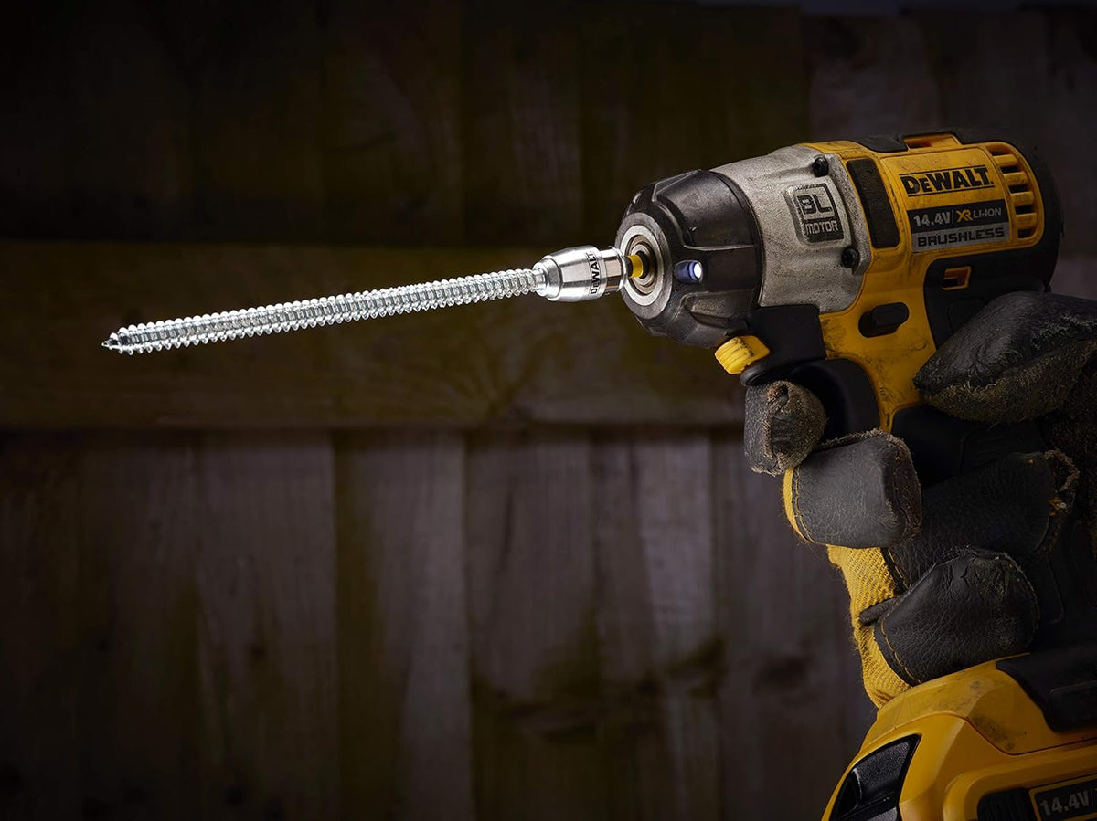 DeWalt magnetic screwlock sleeve attached to a drill with a long screw inserted, held by a gloved hand.