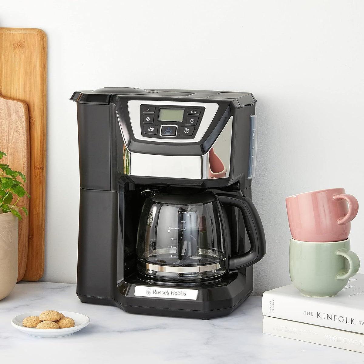 Russell Hobbs Chester black coffee maker with glass carafe, digital display, and control buttons on a kitchen counter.