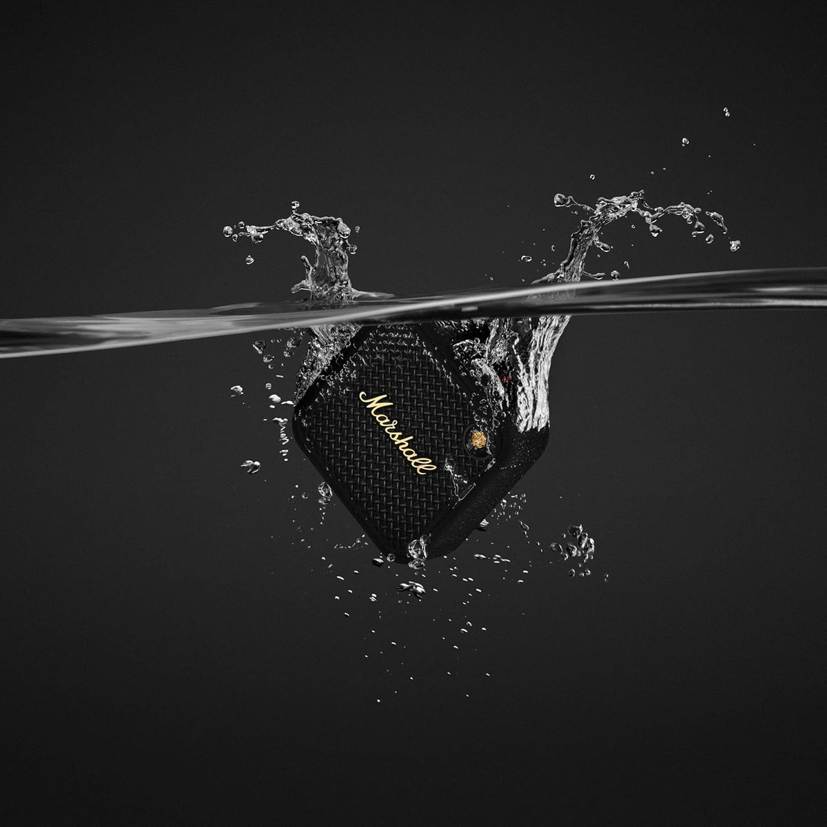 Marshall Willen II Black & Brass speaker partially submerged in water with splash against black background
