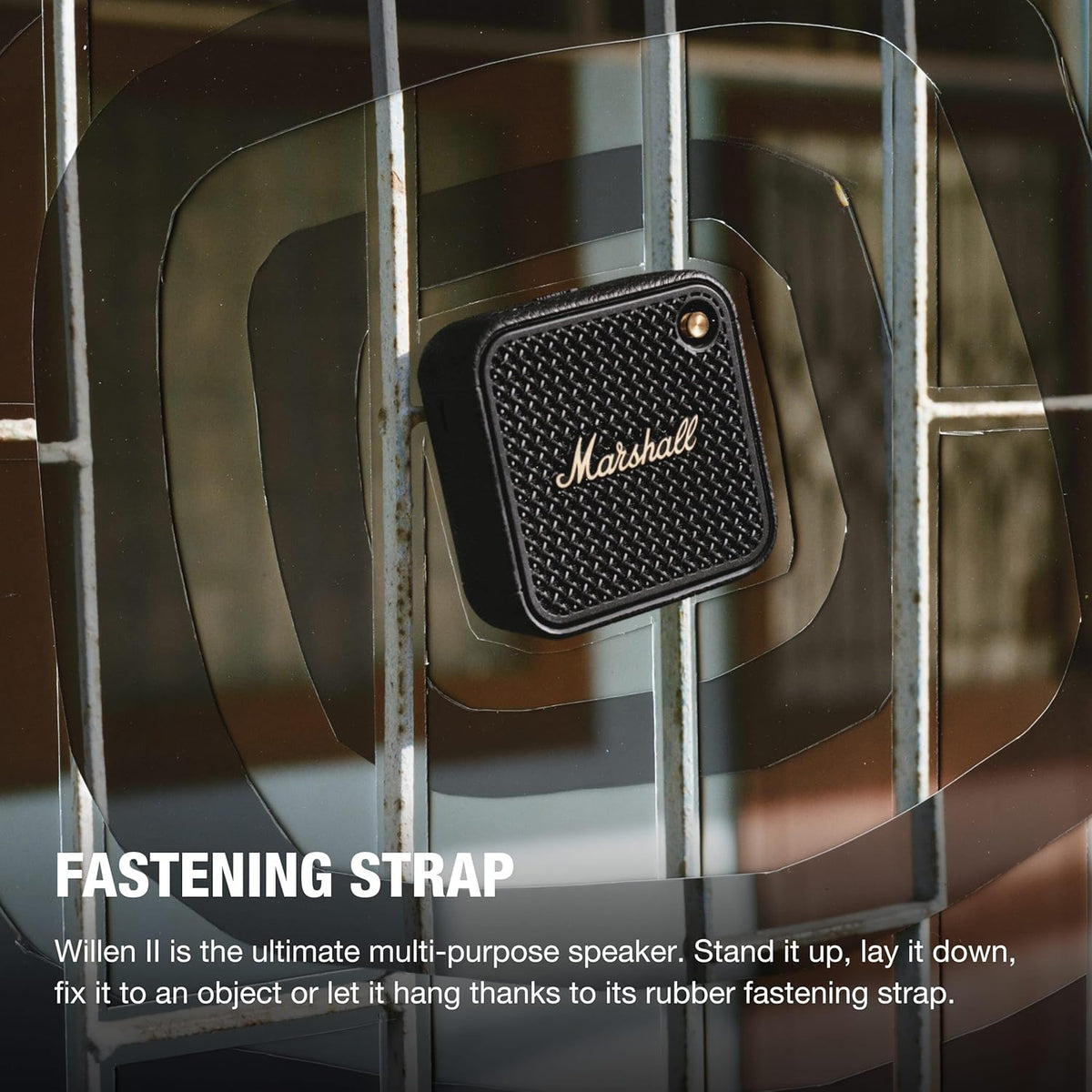Marshall Willen II Black & Brass speaker attached to metal bars with its rubber fastening strap visible