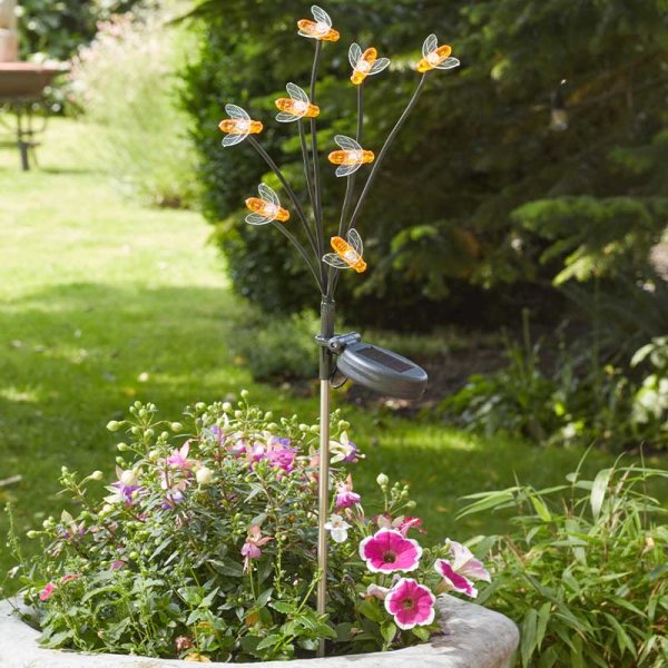 8-stem bee-shaped solar stake light glowing above pink and white flowers in a garden planter