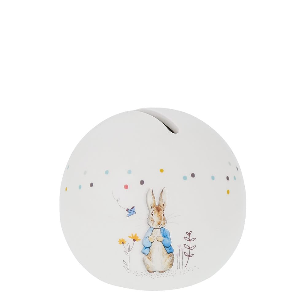 White spherical money bank with Peter Rabbit illustration and colorful dots around the top edge.