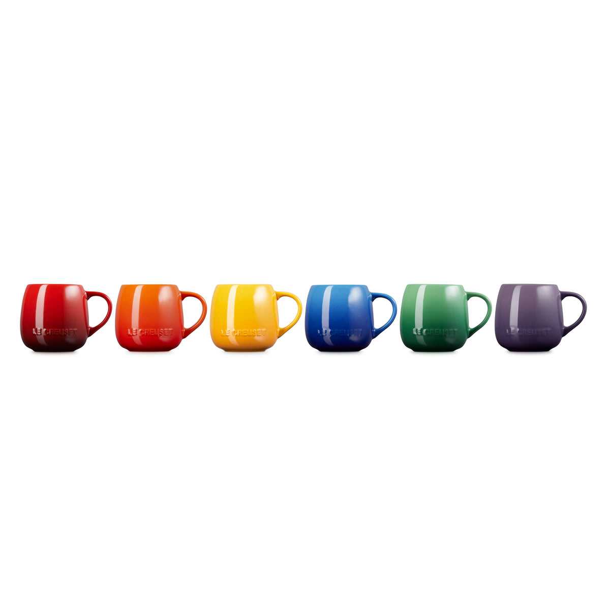 Six colorful Le Creuset coupe mugs in red, orange, yellow, blue, green, and purple, shown upside down.