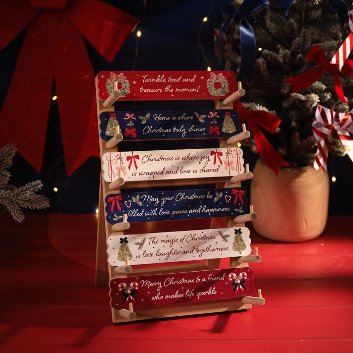 Merry Little Bows wood table top block set with six festive sentiment plaques on a wooden stand, holiday decor.