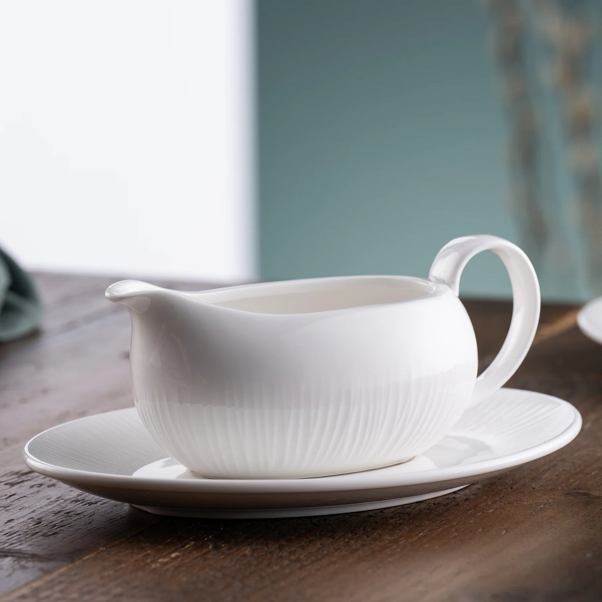White ceramic Erne sauce and gravy boat with matching tray on wooden surface