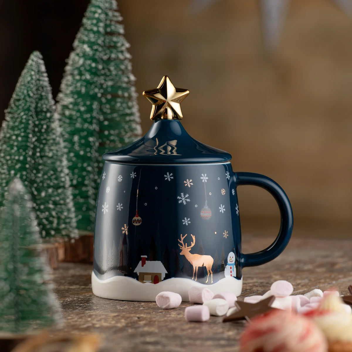 Blue Belleek Winter Scene lidded mug with gold star knob, snowman, reindeer, and snowy cabin design.