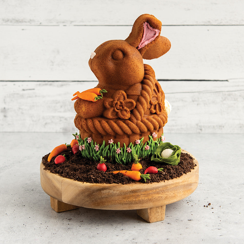 Toffee Bunny in a Basket Pan cake with carrot and flower decorations on a wooden stand