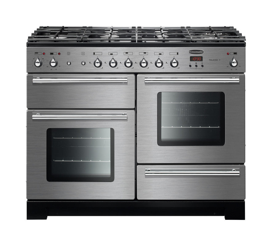 Rangemaster Toledo + 110 dual fuel cooker with six burners, two ovens, and a warming drawer in stainless steel.