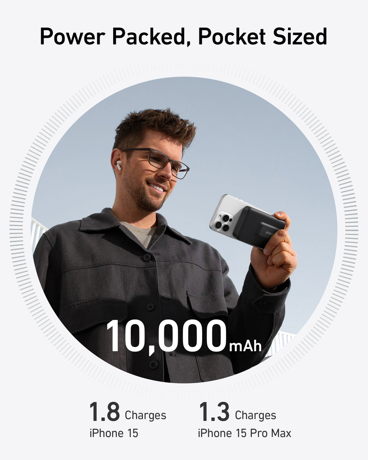 Man holding iPhone 15 with black Anker MagGo Power Bank (10K) attached on a clear day