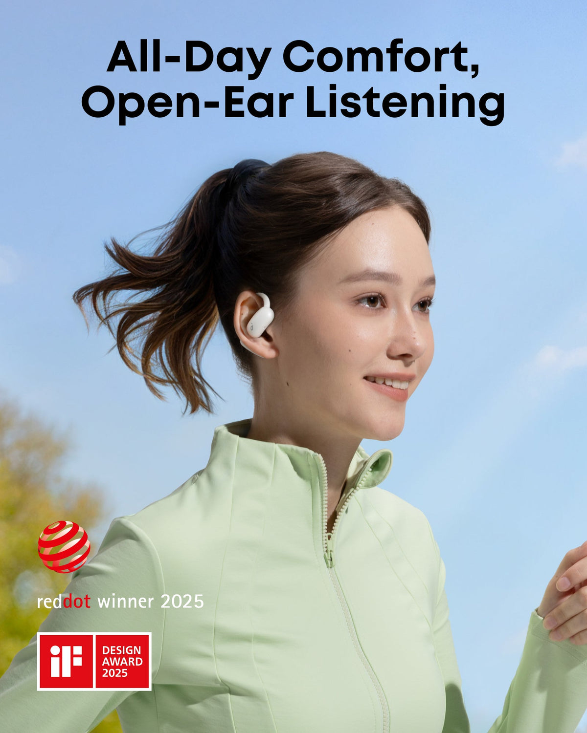 Woman wearing white Soundcore AeroFit 2 open-ear earbuds outdoors with a light green jacket