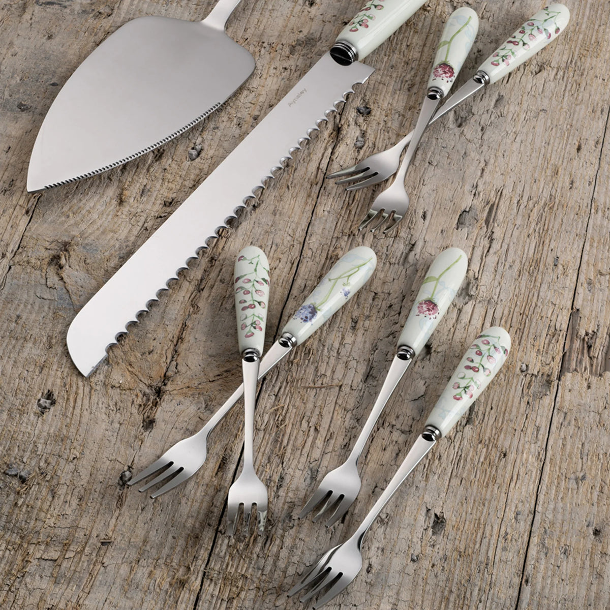 Camille Pale Jade Pastry Set with floral-patterned handles on forks and cake server on wooden surface