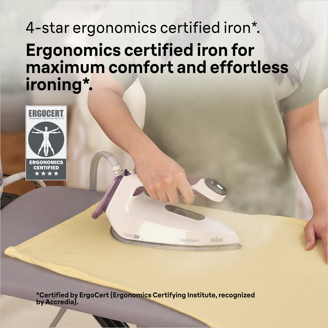 Braun Carestyle 5 steam generator iron in white and violet, held by a person ironing a yellow garment.