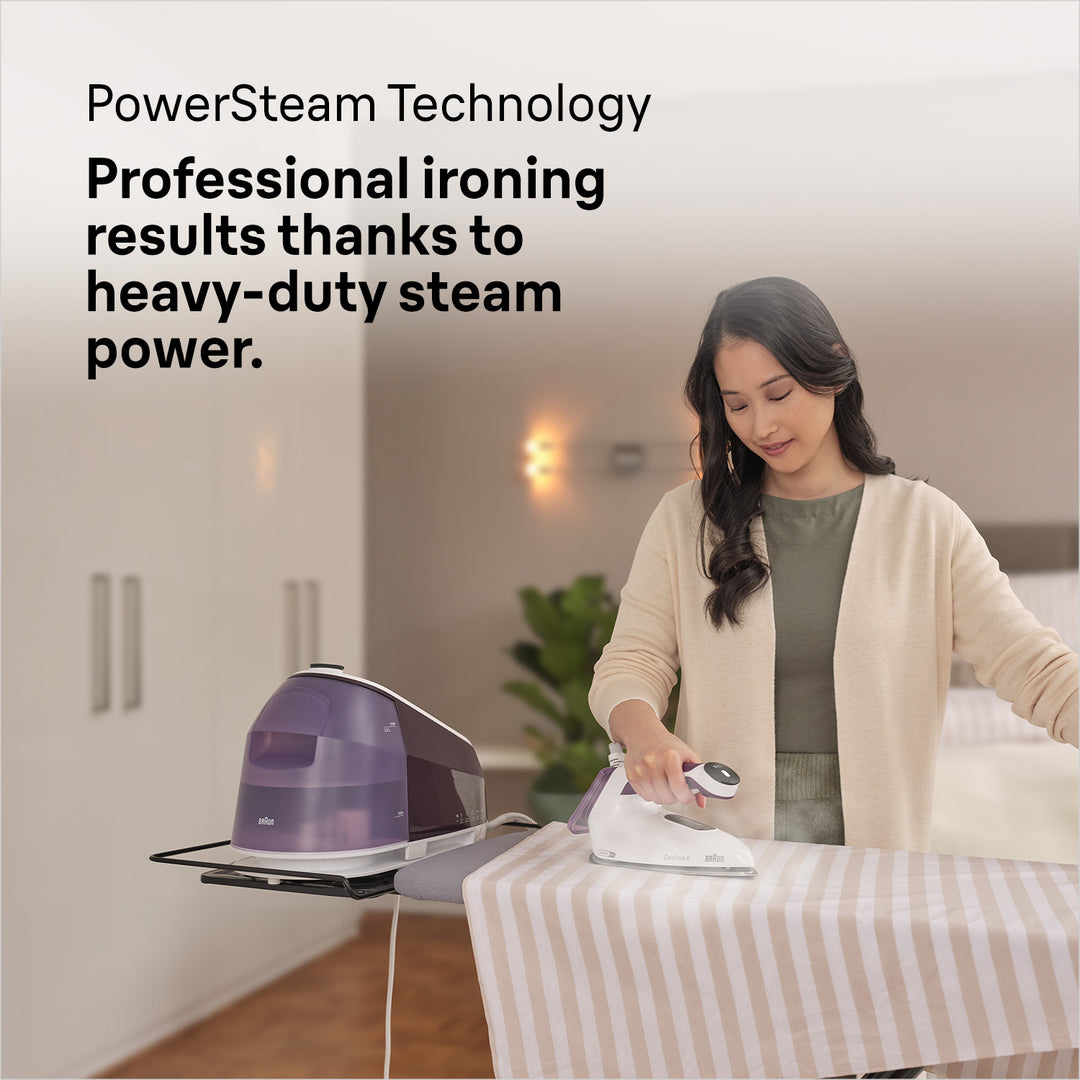 Braun Carestyle 5 steam generator iron in white and violet on ironing board with woman ironing striped fabric.