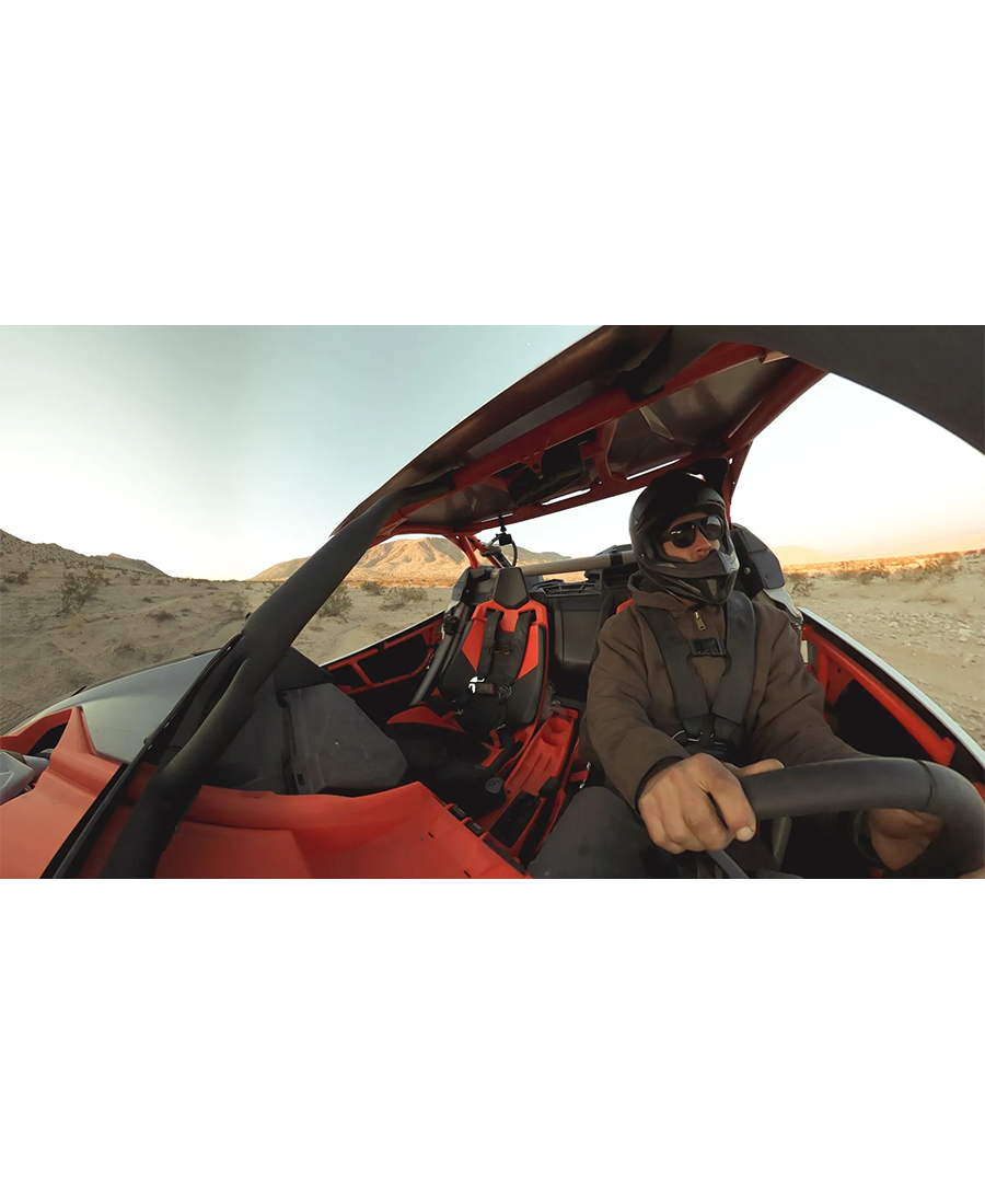 GoPro Hero Max 360 camera mounted inside a red off-road vehicle with driver wearing helmet and sunglasses