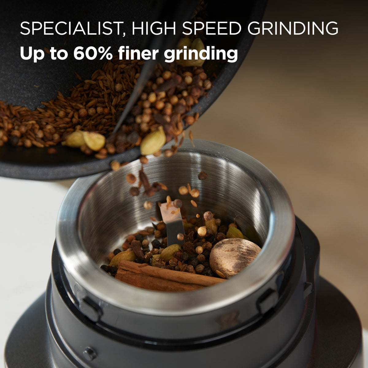 Kenwood Autograph Duo Prep grinder with spices being poured into the stainless steel grinding bowl