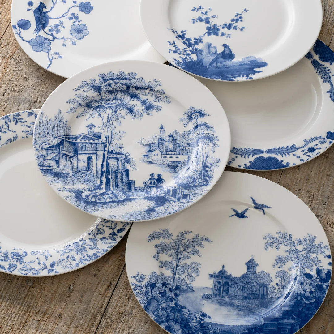 Six Aynsley Archive Blue fine china teaplates with varied blue scenic and floral designs on a wooden surface.