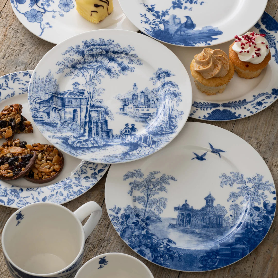 Archive Blue Aynsley teaplates with blue scenic and floral designs, arranged with sweets on a wooden surface.