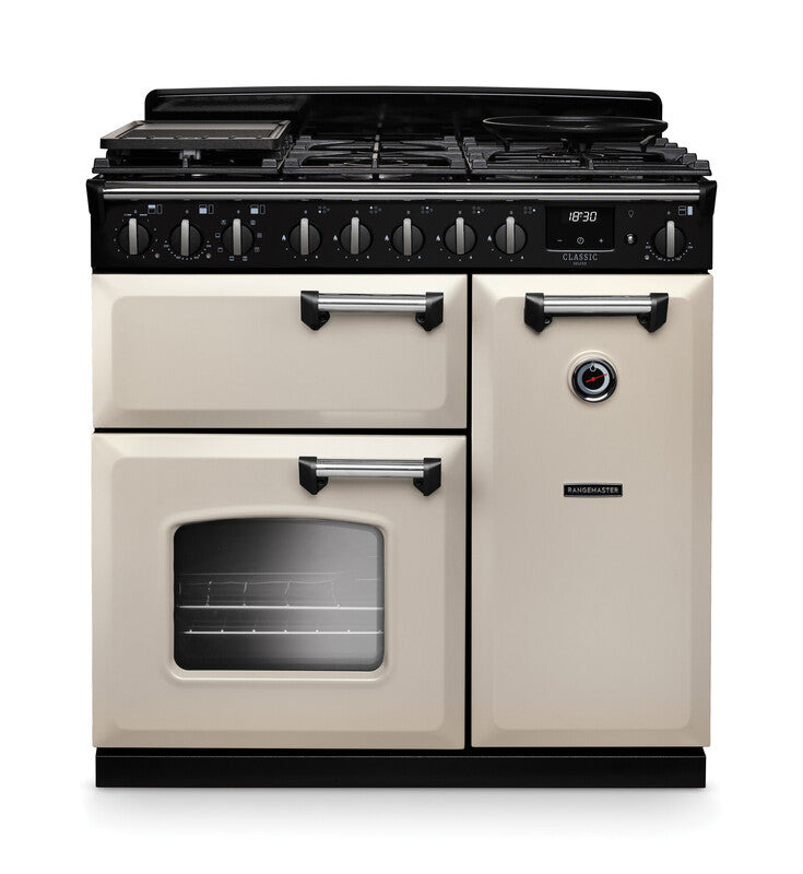 Rangemaster Classic Deluxe 90cm chrome dual fuel rangecooker in cream with multiple ovens and control knobs