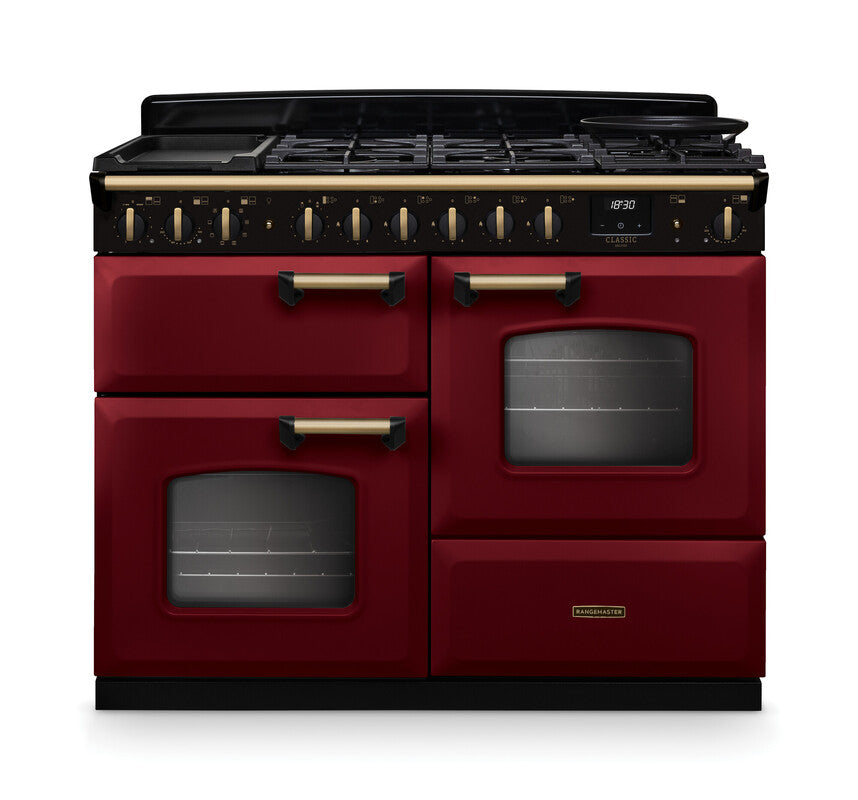 Rangemaster Classic Deluxe 110 dual fuel cooker in deep red with antique brass handles and trim, front view.