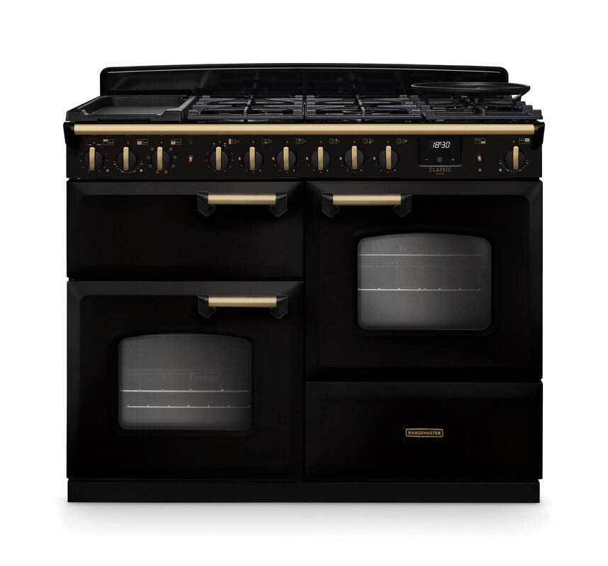 Rangemaster Classic Deluxe 110 cm dual fuel range cooker in black with antique brass trim, two ovens, and gas hob.