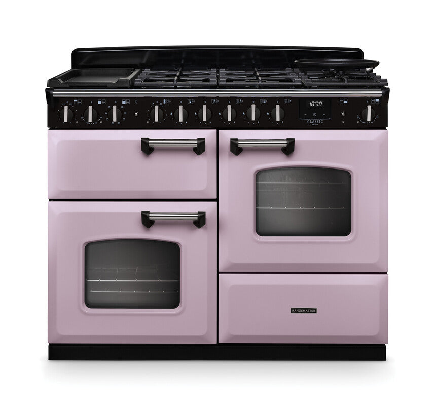 Rangemaster Classic Deluxe 110 dual fuel cooker in pastel pink with chrome handles and black control panel
