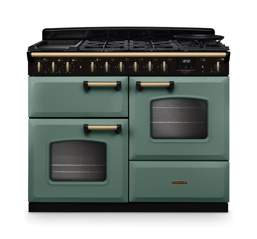 Rangemaster Classic Deluxe 110 dual fuel cooker in green with antique brass handles and trim, two ovens, and six burners.
