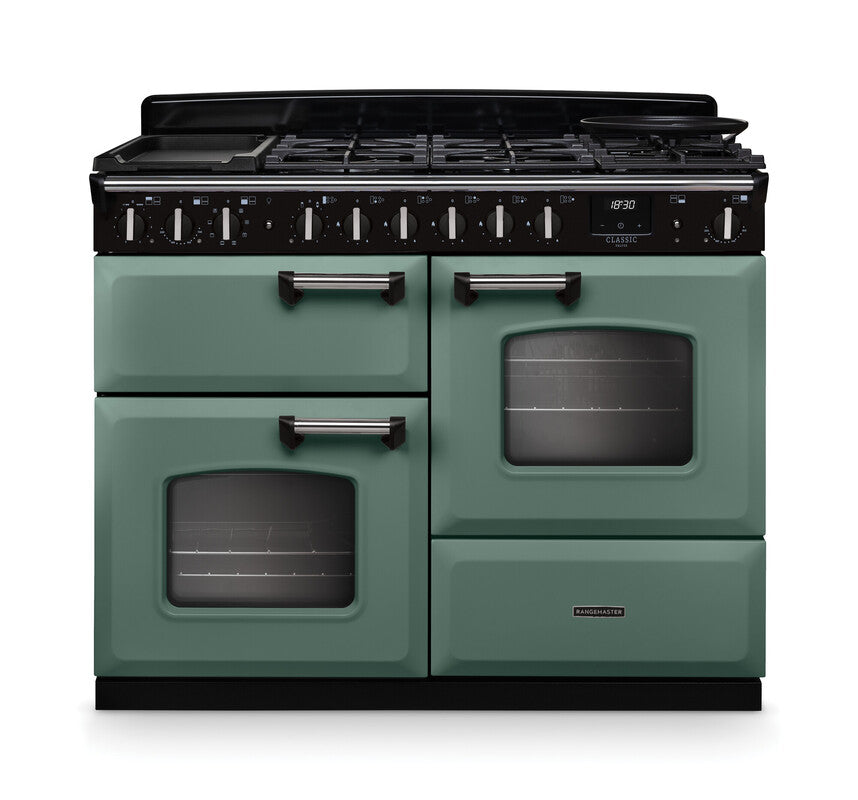 Rangemaster Classic Deluxe 110 dual fuel cooker in green with chrome trim, two ovens, grill, and six burners.