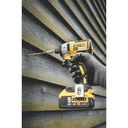 DeWalt power drill being used on a corrugated metal surface