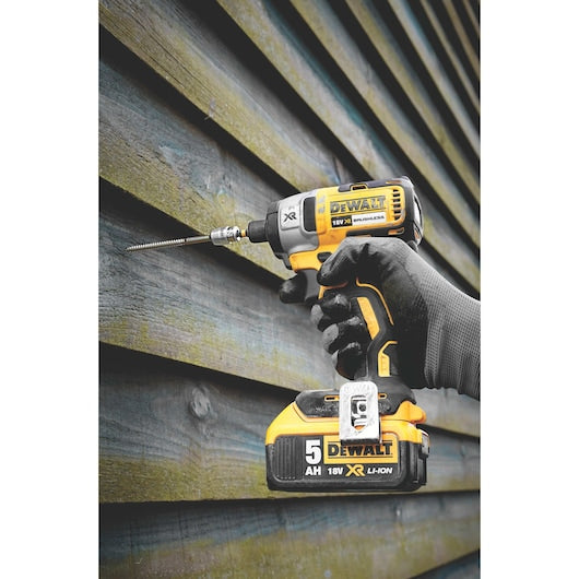 DeWalt power drill being used on a corrugated metal surface
