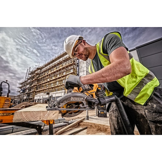 DeWalt 54v Flexvolt High Torque Circular Saw cutting wood on a construction site, held by a worker in safety gear.