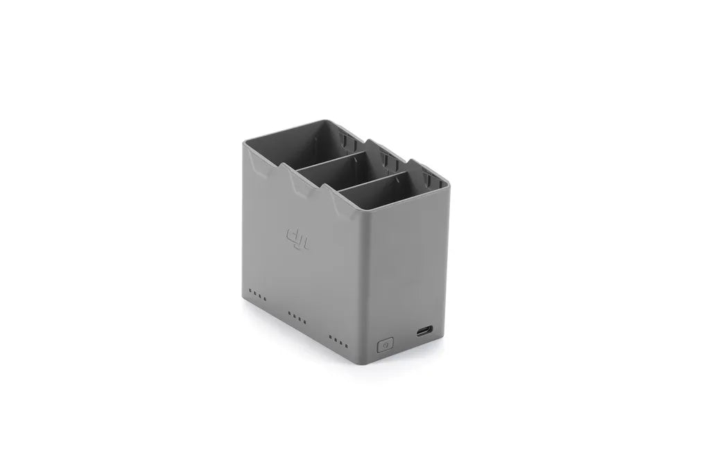 DJI Mini 5 Pro Two-Way Charging Hub in gray, showing three battery slots and USB-C port on white background.