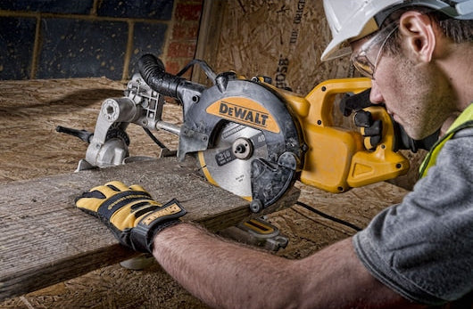 DeWalt 216mm 40T circular saw blade installed on a saw cutting a wooden plank with a gloved hand guiding it.