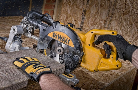 DeWalt circular saw with 216mm 40T blade cutting a wooden plank, held by a gloved hand.