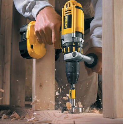 DeWalt 25mm self-feed drill bit attached to a yellow cordless drill, drilling into wood framing.