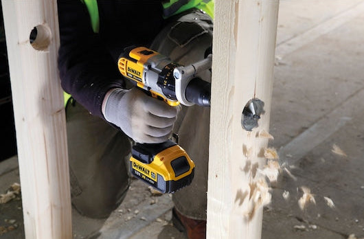 DeWalt self-feed drill bit 25mm attached to a drill, boring a hole in a wooden beam.