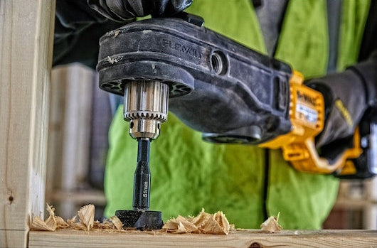 DeWalt Self-Feed Drill Bit 35mm attached to a drill, cutting into wood with wood shavings around.