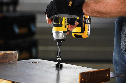 DeWalt cordless impact driver with a rapid load screwdriving bit driving a screw into metal.