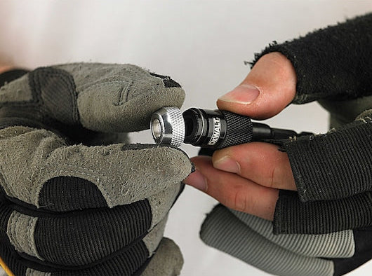 Close-up of gloved hands holding and adjusting the DeWalt DT71514-QZ rapid load screwdriving bit.