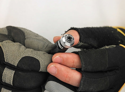 Close-up of a hand wearing gloves holding a DeWalt DT71514-QZ rapid load screwdriving bit.