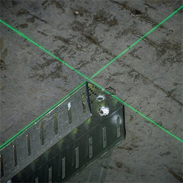 Green cross line laser beams projected on a concrete surface with a metal bracket, from DeWalt Cross Line Green Laser
