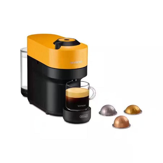 Nespresso coffee machine with a glass of espresso and capsules on a white background