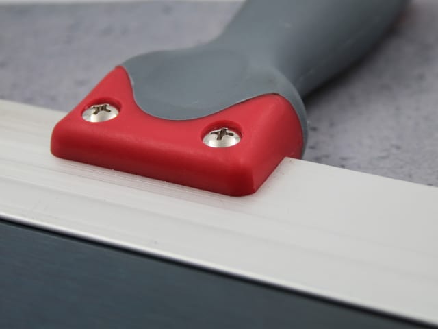 Close-up of Faithfull Drywall Taping Knife showing red and grey handle with blue steel blade edge.