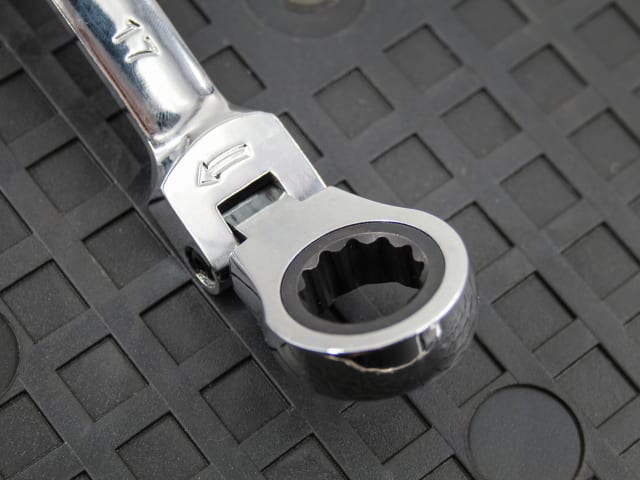 Close-up of the flex head on a Faithfull 17mm ratchet combination spanner on a textured black surface.