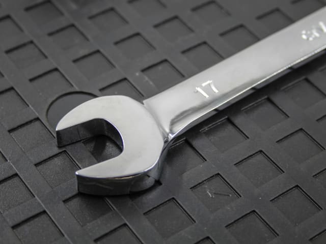 Close-up of a 17mm Faithfull ratchet combination spanner with a flex head on a textured black surface.