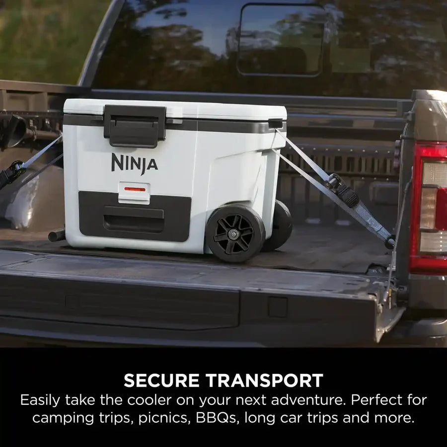 Ninja FrostVault white wheeled cooler secured with straps in the back of a pickup truck