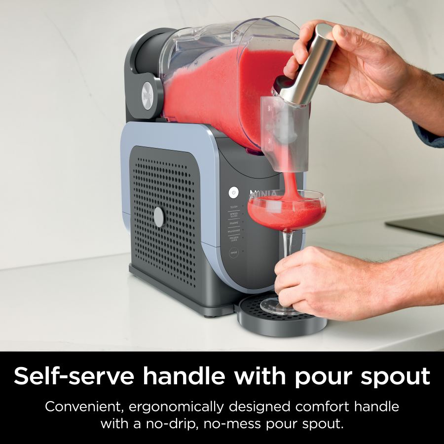 Ninja SLUSHi frozen drink maker dispensing red slush into a glass using the self-serve handle with pour spout
