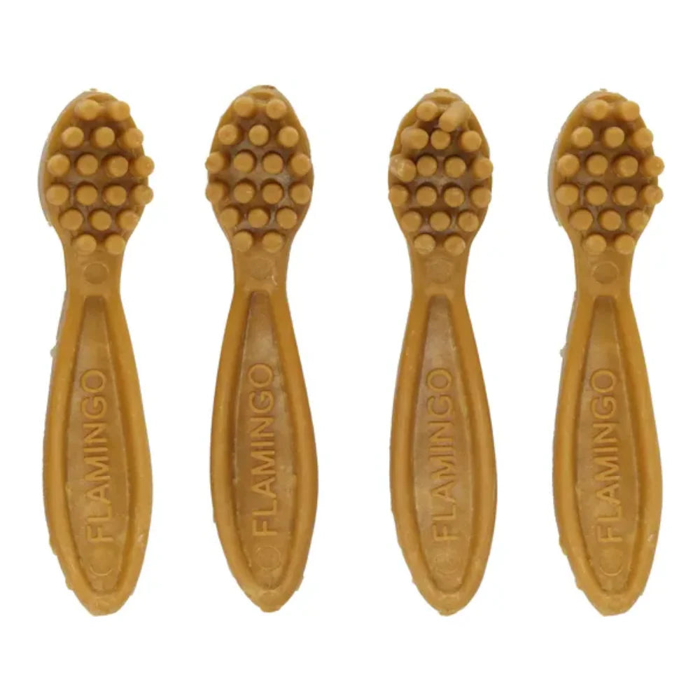 Four pineapple-flavored dog toothbrush sticks with textured heads and FLAMINGO embossed on handles.