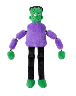 A plush doll styled like Frankenstein's monster, featuring green skin, a purple fuzzy shirt, black pants, and green shoes, set against a plain white background.