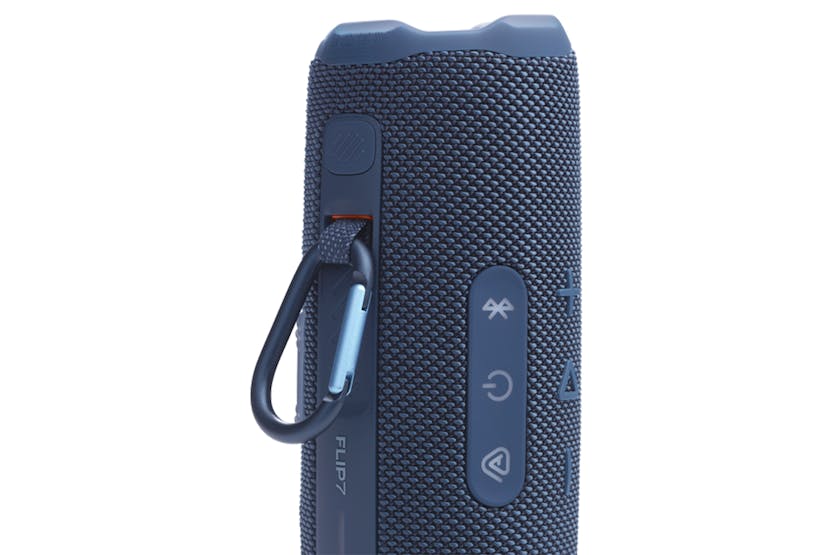 Close-up of the blue JBL Flip 7 portable Bluetooth speaker showing side buttons and attached carabiner clip.