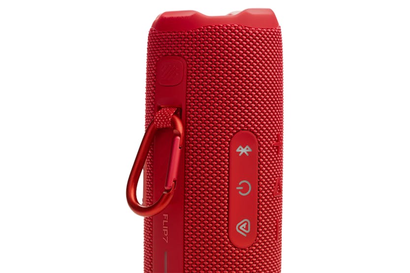 Close-up of the red JBL Flip 7 speaker side showing control buttons and attached carabiner clip.